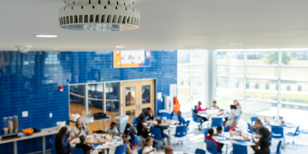 a HALO Smart Sensor in use, which detect air quality issues, vaping, and potential hazards, adding a layer of school safety solutions