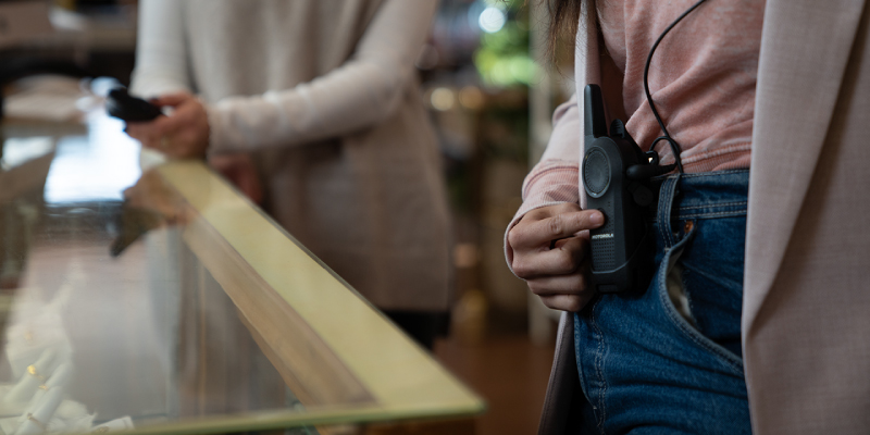 Retail Worker Using the Motorola Curve Two Way Radio PTT Function
