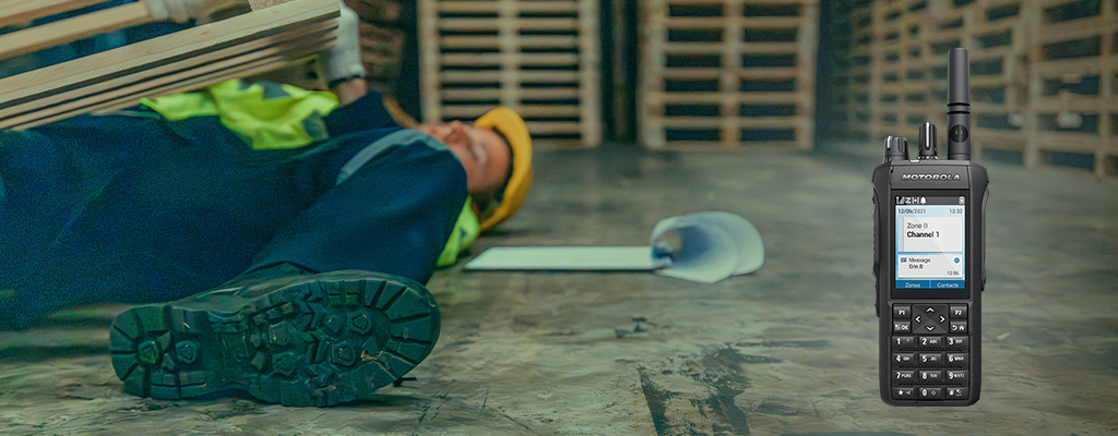 A lone worker in a plant lays hurt beneath a pallet of wood. With the Motorola R7 - a MOTOTRBO radio - they can use the "man down" feature.
