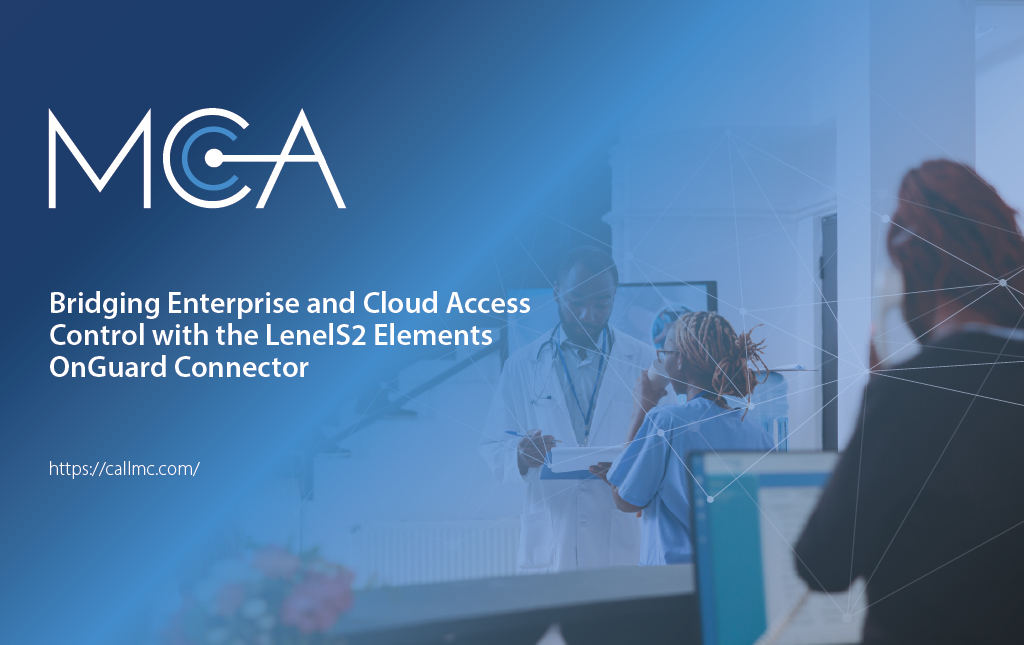 A receptionist at a doctor's office answering a phone in the foreground with a doctor speaking to a nurse in the background.