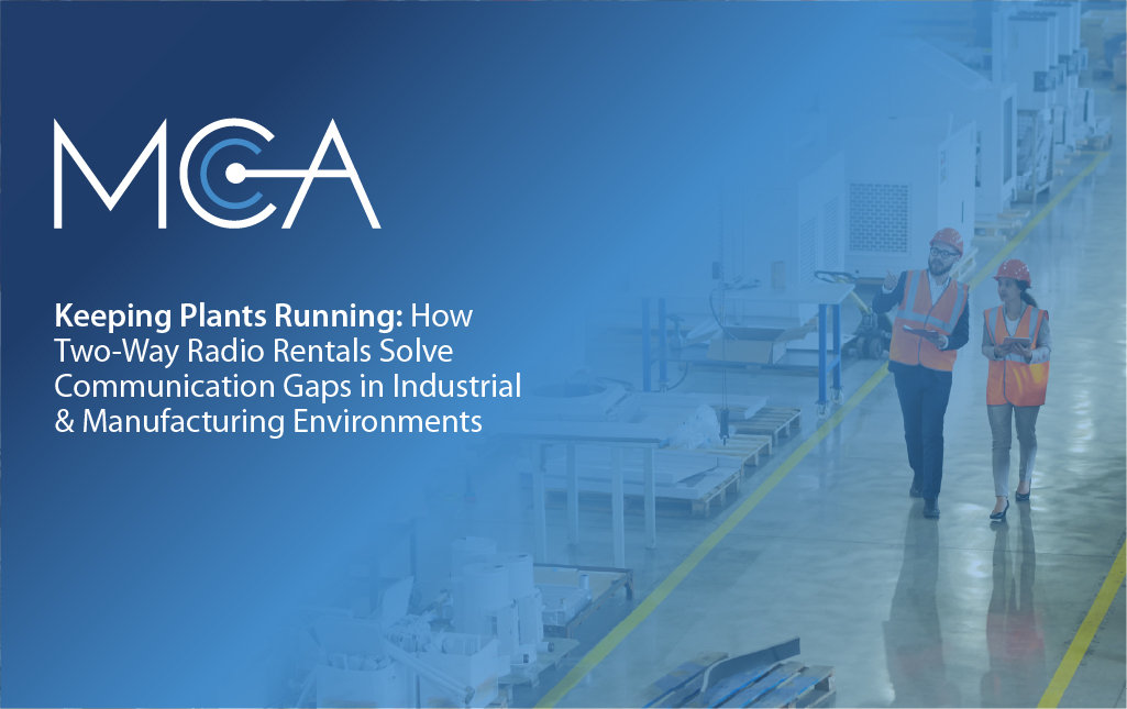Two engineers walk the floor of a manufacturing plant.